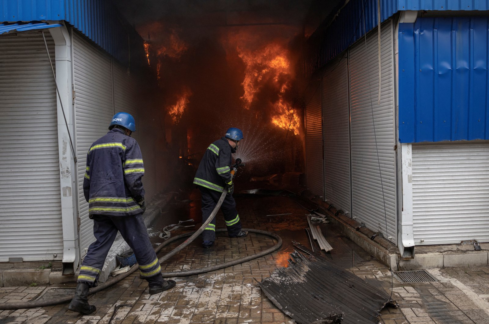 Firefighters spray water onto a fire at the market after shelling in Sloviansk, Donetsk region, Ukraine, July 5, 2022. (Reuters Photo)