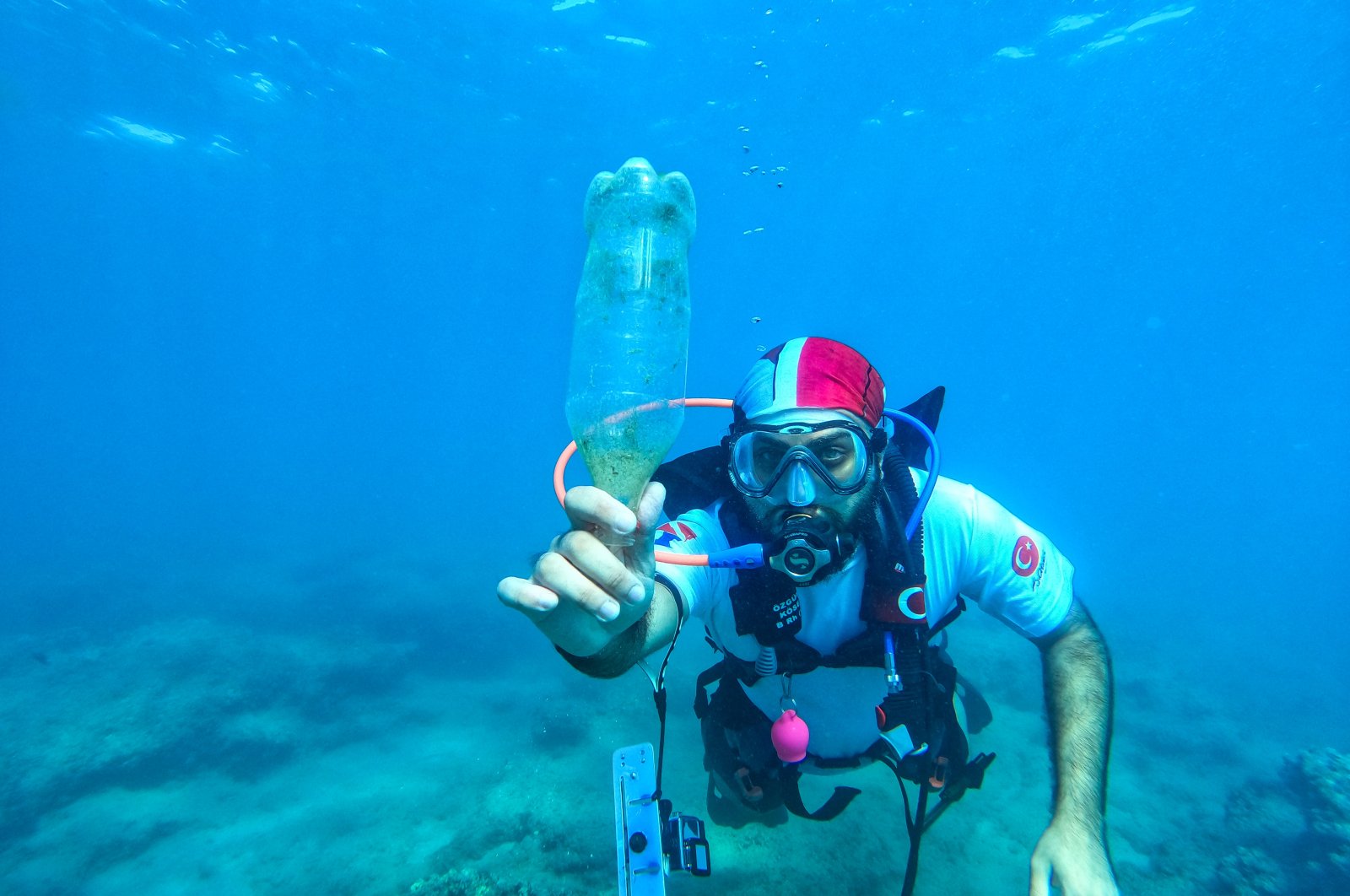A diver shows the plastic bottle he collected in Mersin, southern Turkey, July 6, 2022. (AA PHOTO)