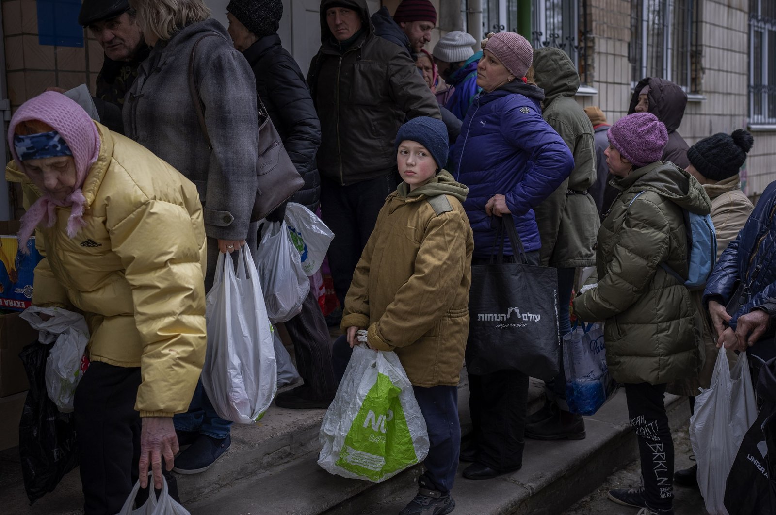 Sergei, 11, waits for his turn to receive donated food during an aid humanitarian distribution in Bucha, in the outskirts of Kyiv, Ukraine, April 19, 2022. (AP Photo)