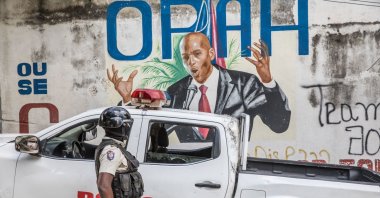 A police officer stands by a wall painted with a mural of late Haitian President Jovenel Moise after FBI agents and forensic teams conducted searches in his residence in Port-au-Prince, Haiti, July 15, 2021, July 7, 2021. (AFP Photo)