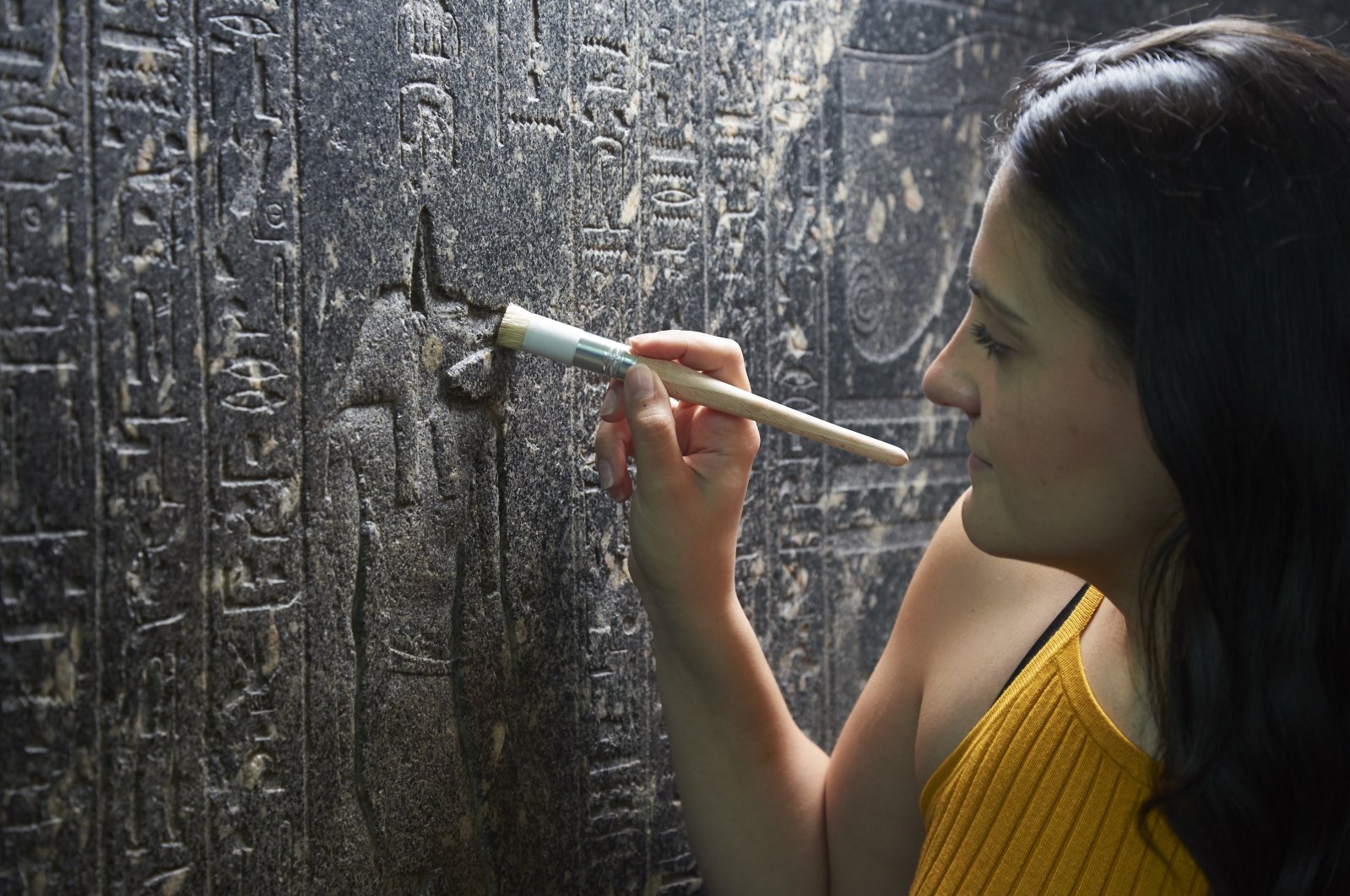 British Museum Senior Conservator Stephanie Vasiliou cleans &quot;The Enchanted Basin&quot;, a large black granite sarcophagus covered with hieroglyphs from about 600 B.C., in the Egyptian Sculpture Gallery at the British Museum, London, the U.K. (DPA) 