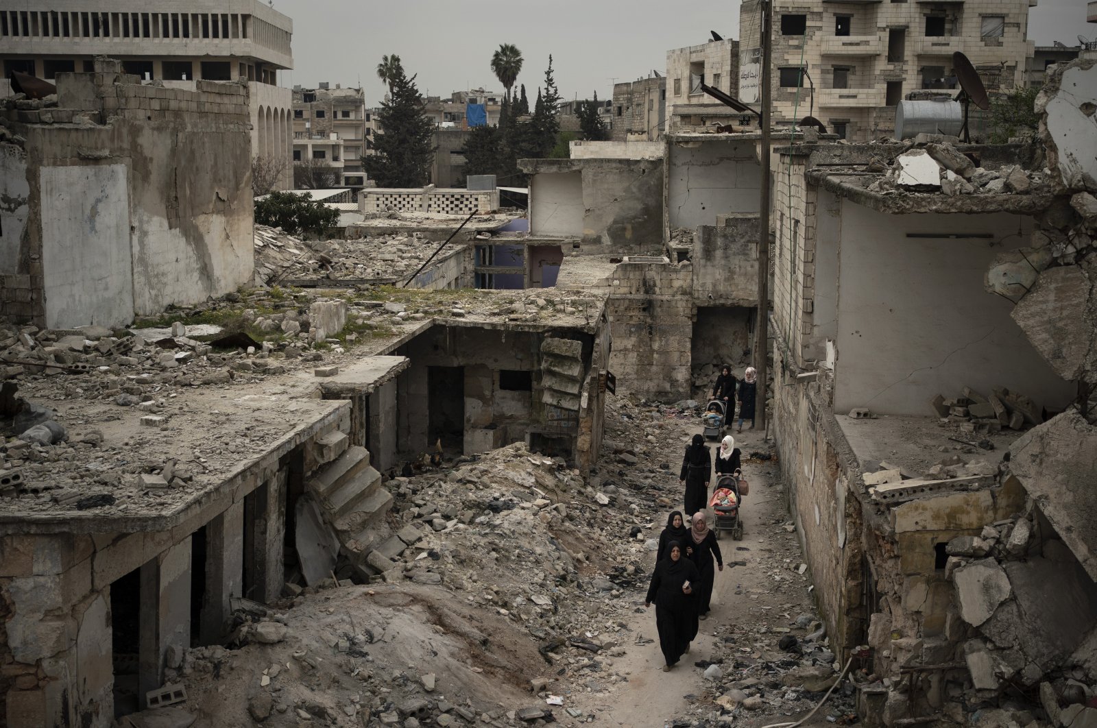 Women walk in a neighborhood heavily damaged by airstrikes in Idlib, Syria, March 12, 2020. (AP Photo)