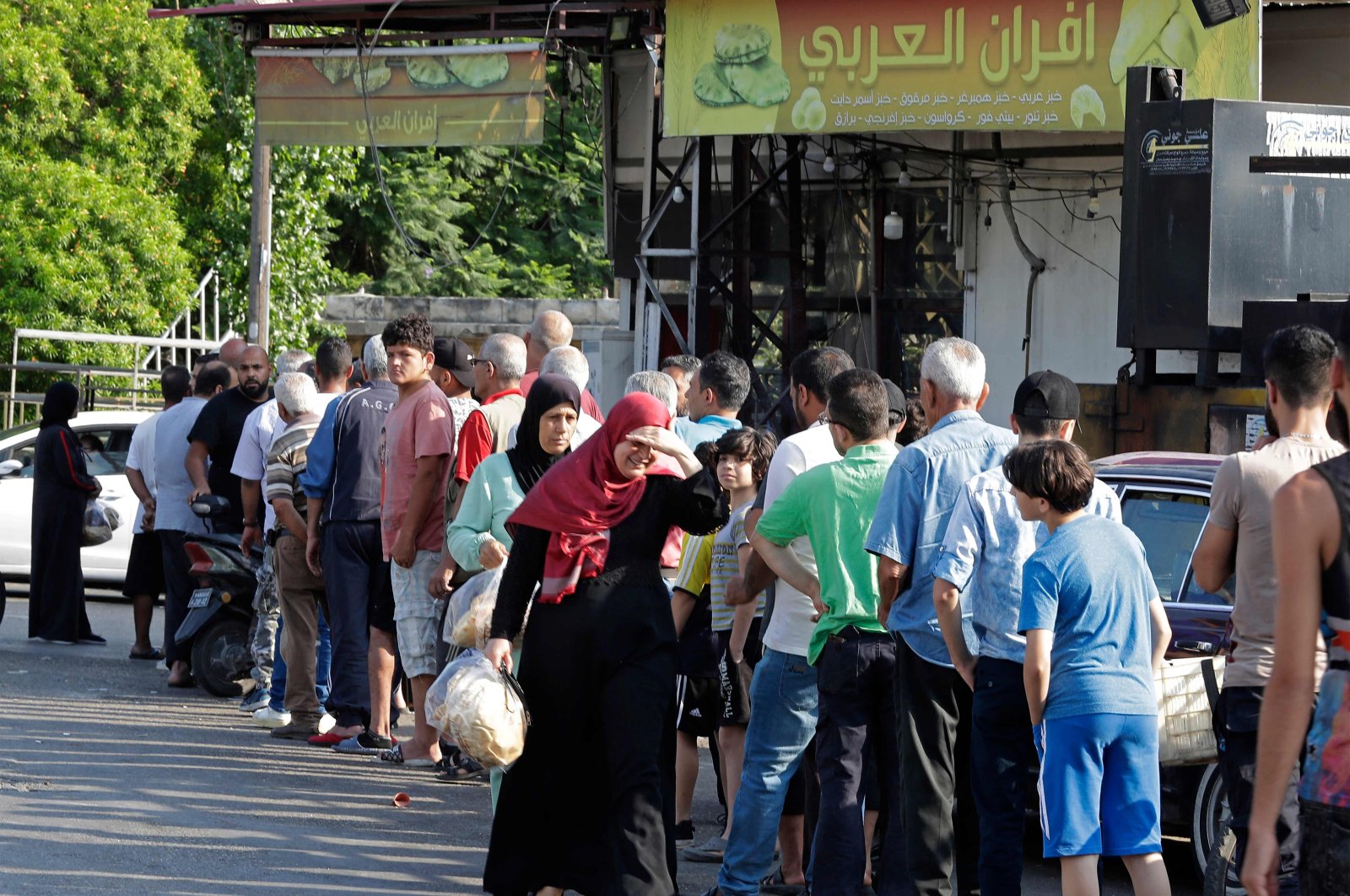 People line up in front of a bakery to buy bread in Sidon, southern Lebanon, June 22, 2022. (AFP Photo)