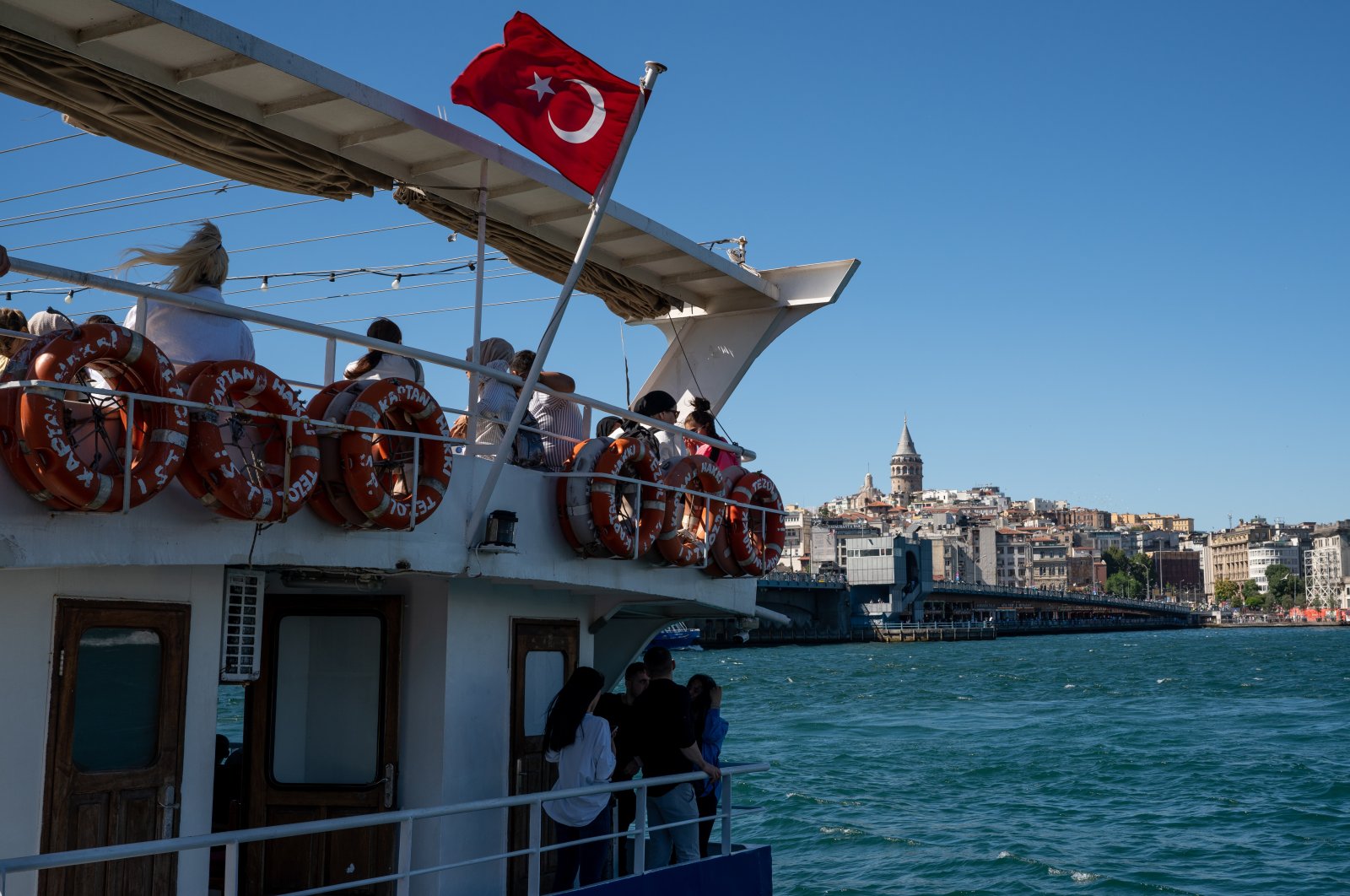 People are seen at a Bosporus ferry with the Galata Tower seen in the background, in the downtown of Istanbul, Turkey, July 3, 2022. (Reuters Photo)