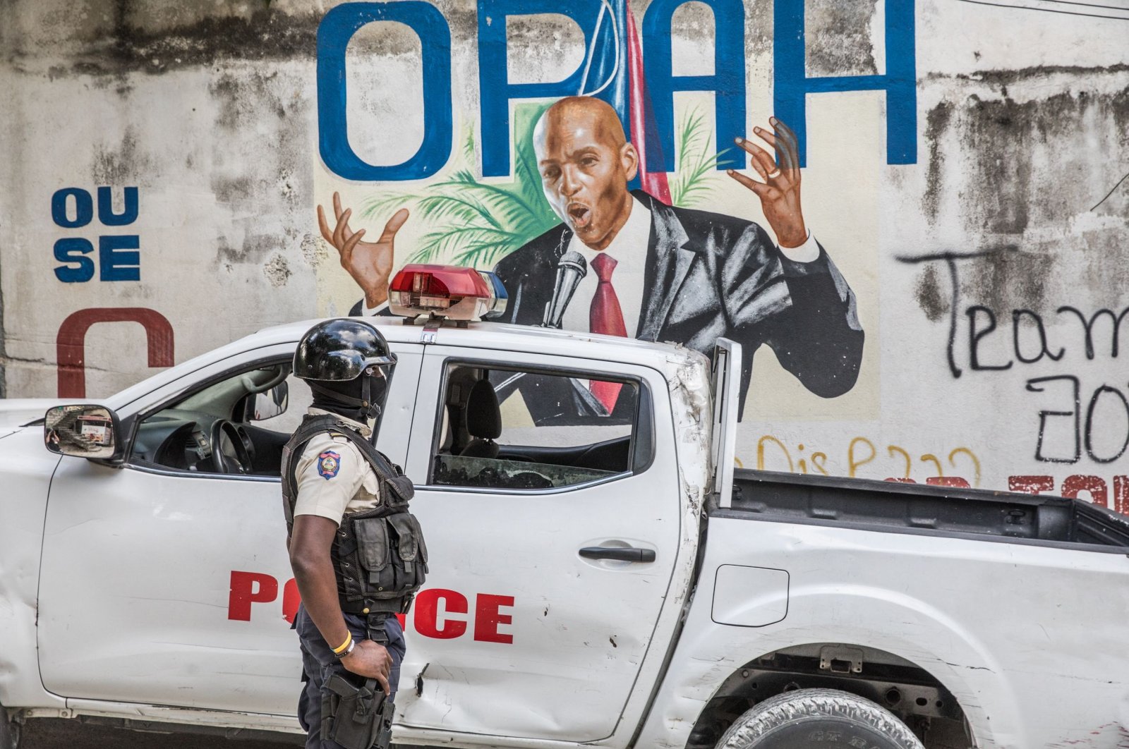A police officer stands by a wall painted with a mural of late Haitian President Jovenel Moise after FBI agents and forensic teams conducted searches in his residence in Port-au-Prince, Haiti, July 15, 2021, July 7, 2021. (AFP Photo)