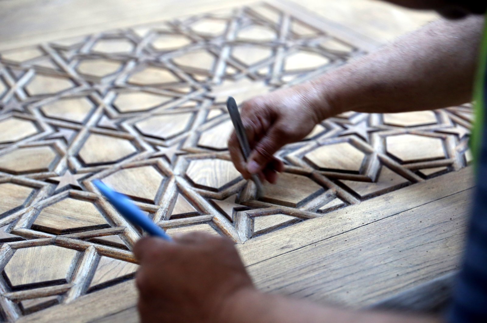 An expert restores one of the doors constructed with the kündekari technique, which is a decorative art consisting of interlocked geometrical pieces, Edirne, Turkey, June 10, 2022. (AA Photo)