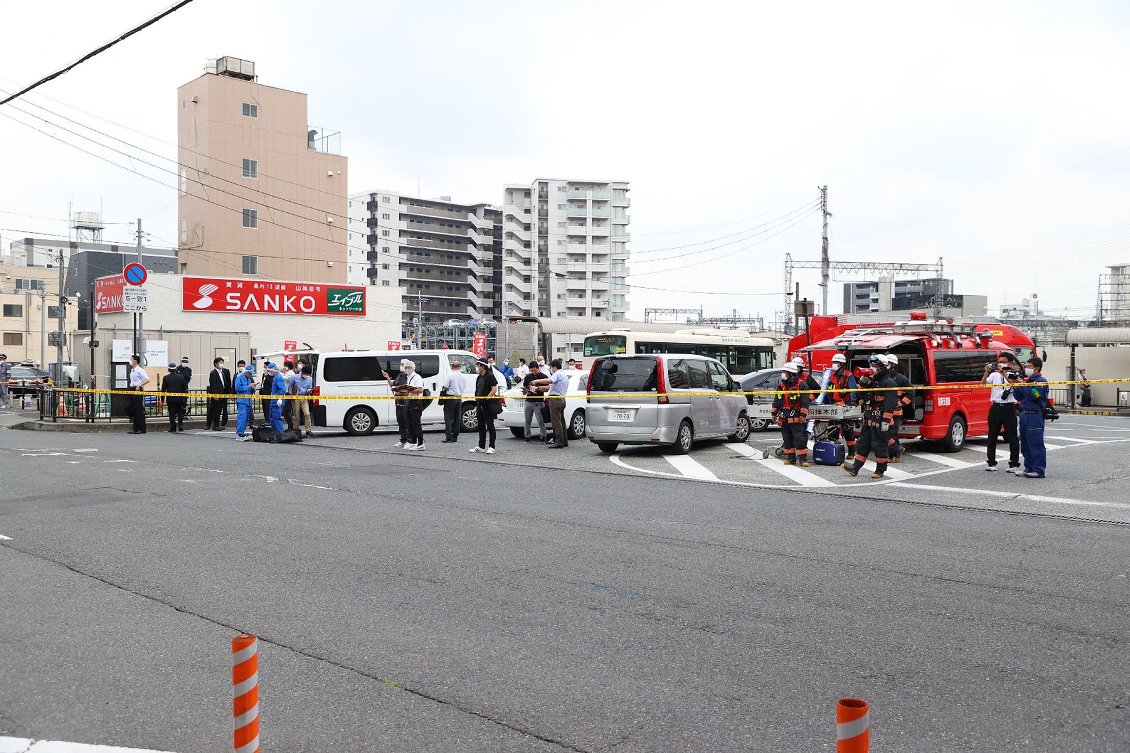 Pemandangan umum menunjukkan para pekerja di tempat kejadian setelah serangan terhadap mantan perdana menteri Jepang Shinzo Abe di alun-alun stasiun Kintetsu Yamato-Saidaiji di Nara, Jepang barat, 8 Juli 2022. (AFP Photo)
