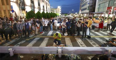 People pray at a makeshift memorial at the scene where former Prime Minister Shinzo Abe was shot during an election campaign in Nara, Japan, July 8, 2022. (AP Photo)