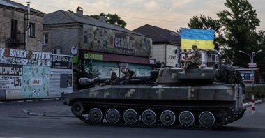 Ukrainian soldiers ride atop a tank through a street in Pokrovsk, Donetsk region, eastern Ukraine, July 8, 2022. (AP Photo)