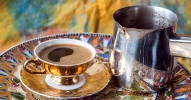 A cup of Turkish coffee next to the traditional pot the drink is brewed in. (Alamy Photo via Reuters)