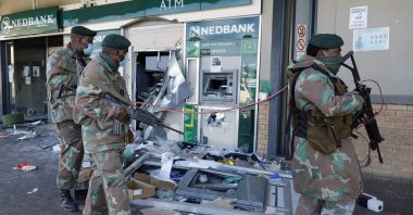 Members of the South African Defence Force walk past an automated teller machine as they patrol the looted Diepkloof Square area in Soweto, Johannesburg, South Africa, July 13, 2021. (AFP File Photo)