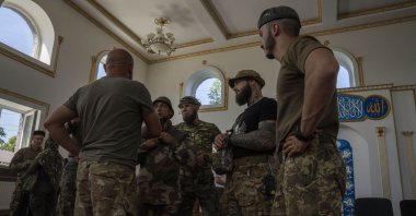 Ukrainian Muslim soldiers talk after prayers on the first day of Eid al-Adha, in Medina Mosque, Konstantinovka, eastern Ukraine, Saturday, July 9, 2022. (AP Photo/Nariman El-Mofty)