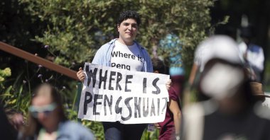A protester holding a sign and wearing a T-shirt reading &quot;Where is Peng Shuai&quot; on day 12 of the 2022 Wimbledon Championships at the All England Lawn Tennis and Croquet Club, Wimbledon, London, Friday, July 8, 2022. (AP Photo)