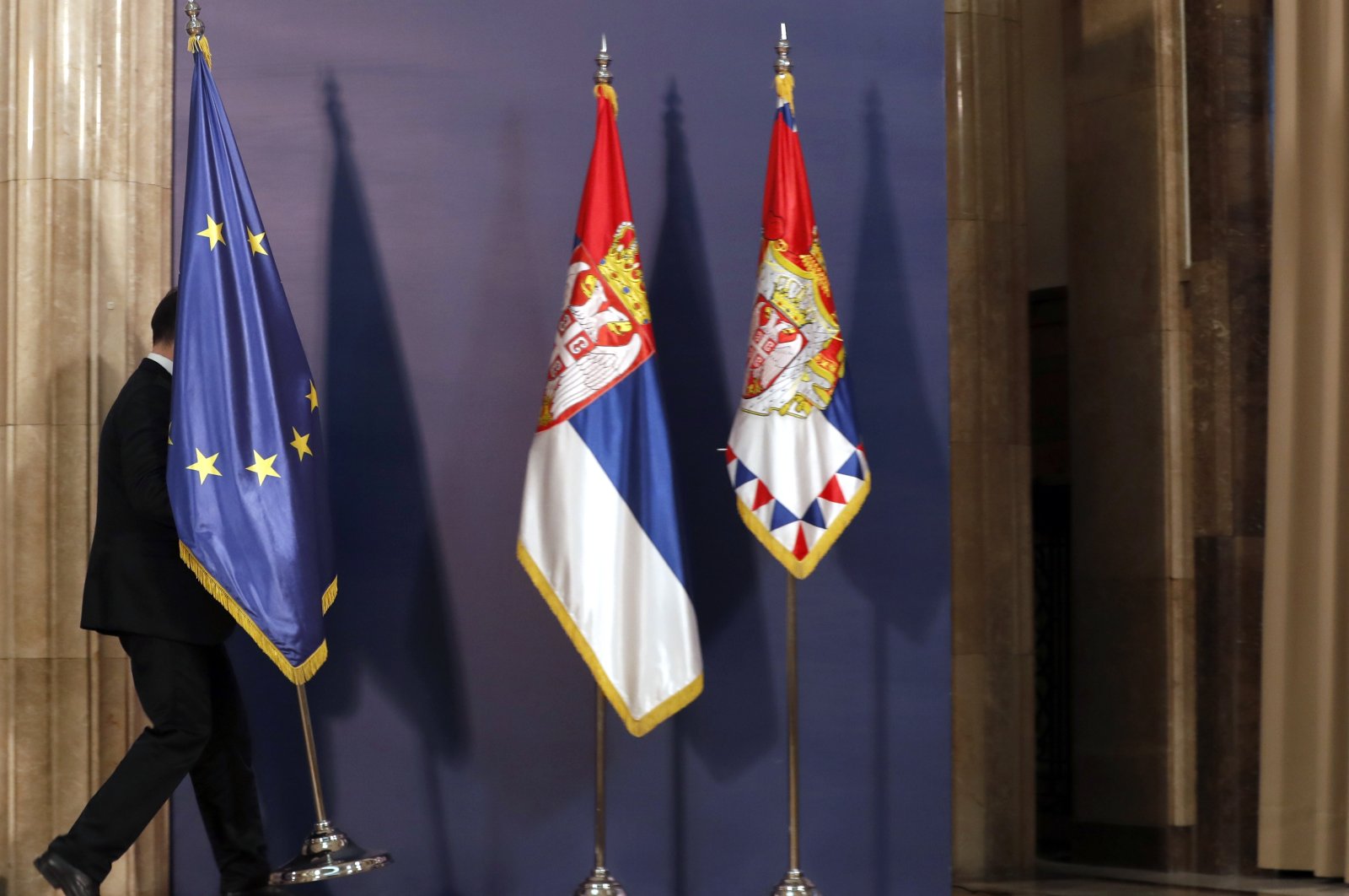 A staff member carries the EU flag before a press conference in Belgrade, Serbia, Friday, Jan. 24, 2020. (AP Photo)