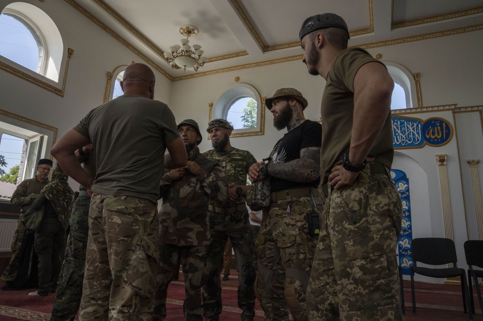 Ukrainian Muslim soldiers talk after prayers on the first day of Eid al-Adha, in Medina Mosque, Konstantinovka, eastern Ukraine, Saturday, July 9, 2022. (AP Photo/Nariman El-Mofty)