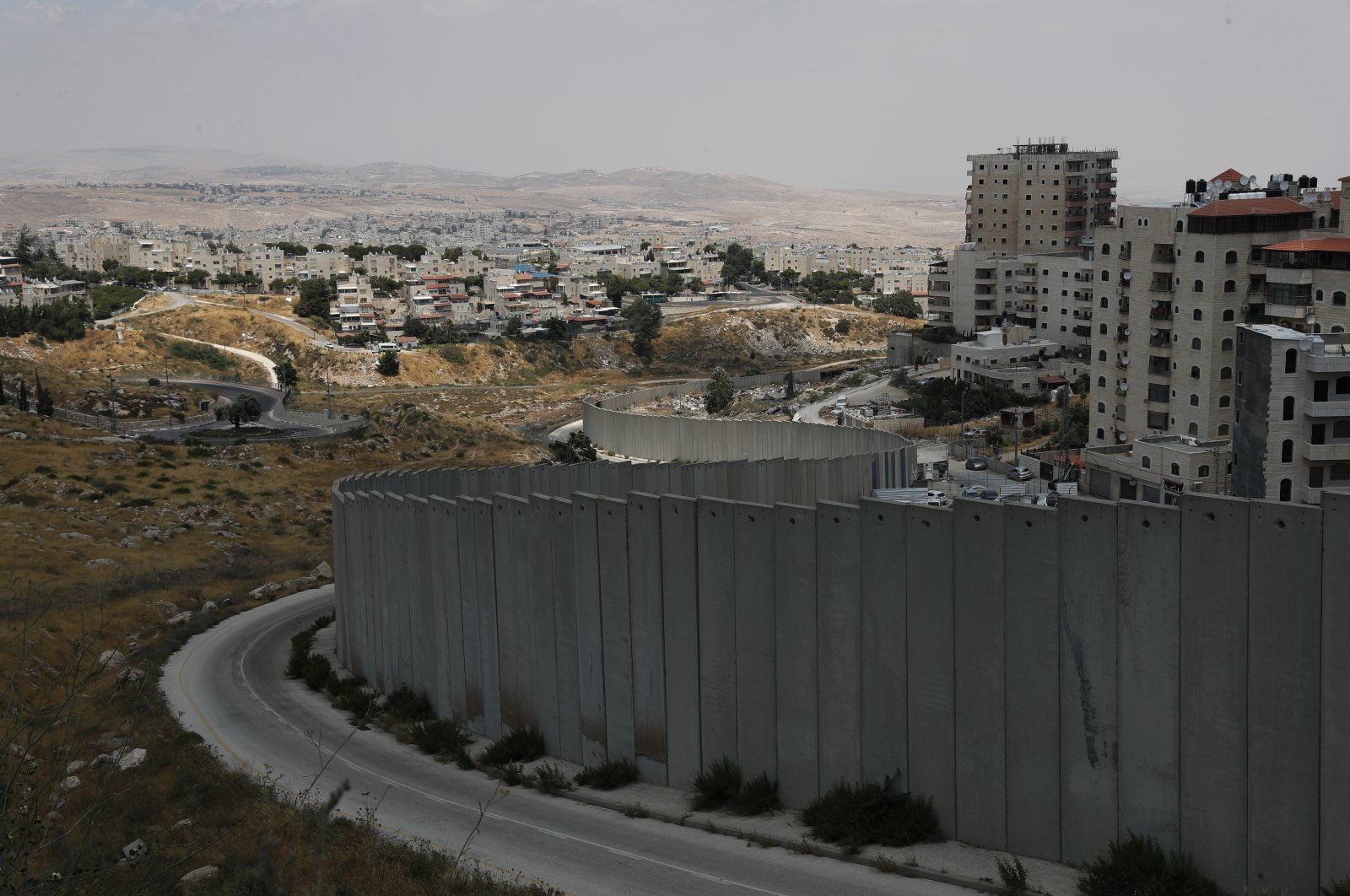 The Palestinian refugee camp of Shuafat is surrounded by the separation barrier (R) and the Israeli settlement of Pisgat Ze&#039;evof (L), north of Jerusalem, June 22, 2022. (EPA Photo)