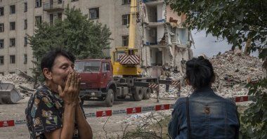Iryna Shulimova, 59, weeps at the scene in the aftermath of a Russian rocket that hit an apartment residential block, in Chasiv Yar, Donetsk region, eastern Ukraine, July 10, 2022. (AP Photo)