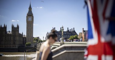 People walk along the Southbank with The Palace of Westminster, home to the Houses of Parliament, London, England, July 8, 2022. (EPA Photo)