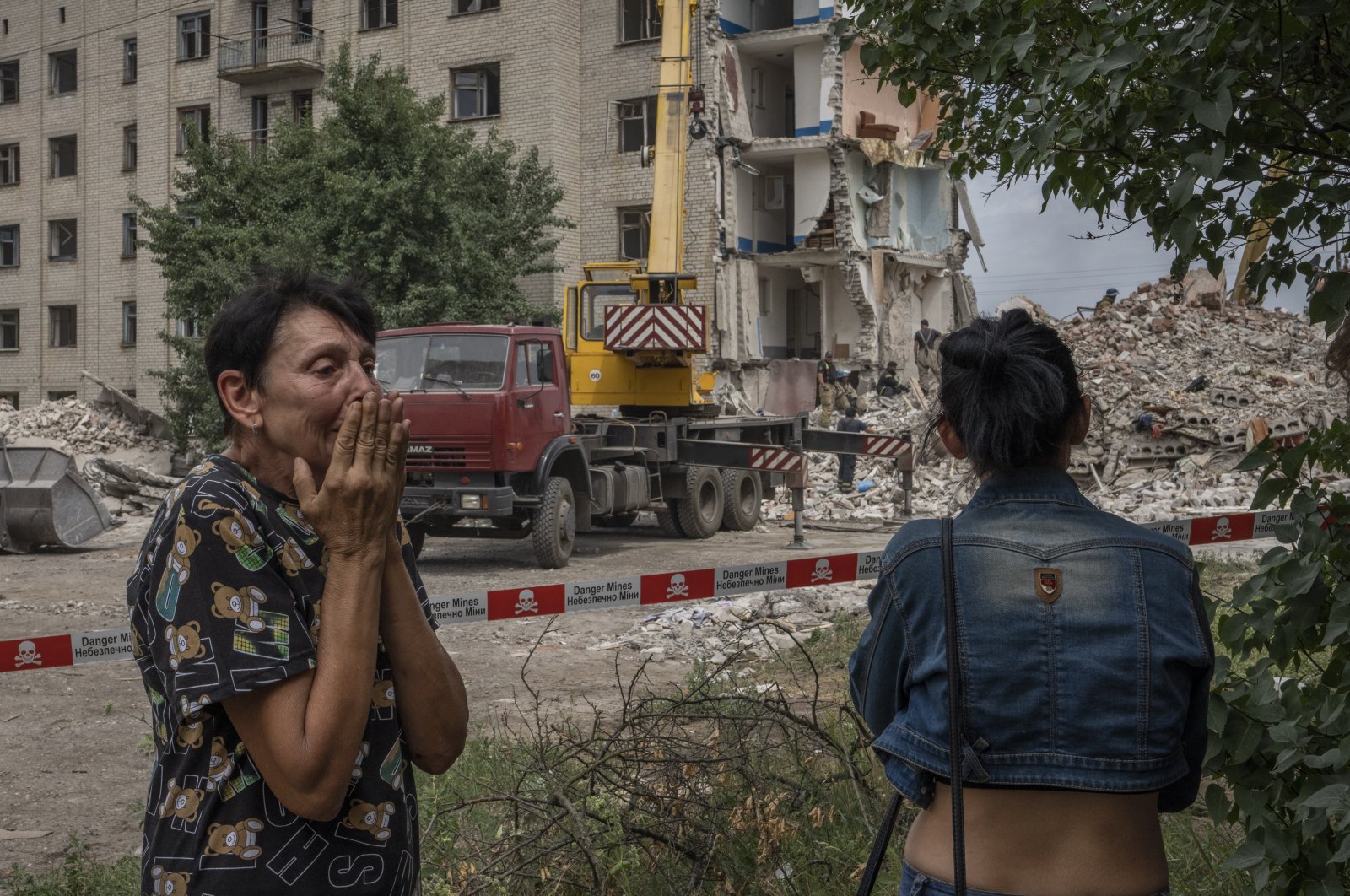 Iryna Shulimova, 59, weeps at the scene in the aftermath of a Russian rocket that hit an apartment residential block, in Chasiv Yar, Donetsk region, eastern Ukraine, July 10, 2022. (AP Photo)