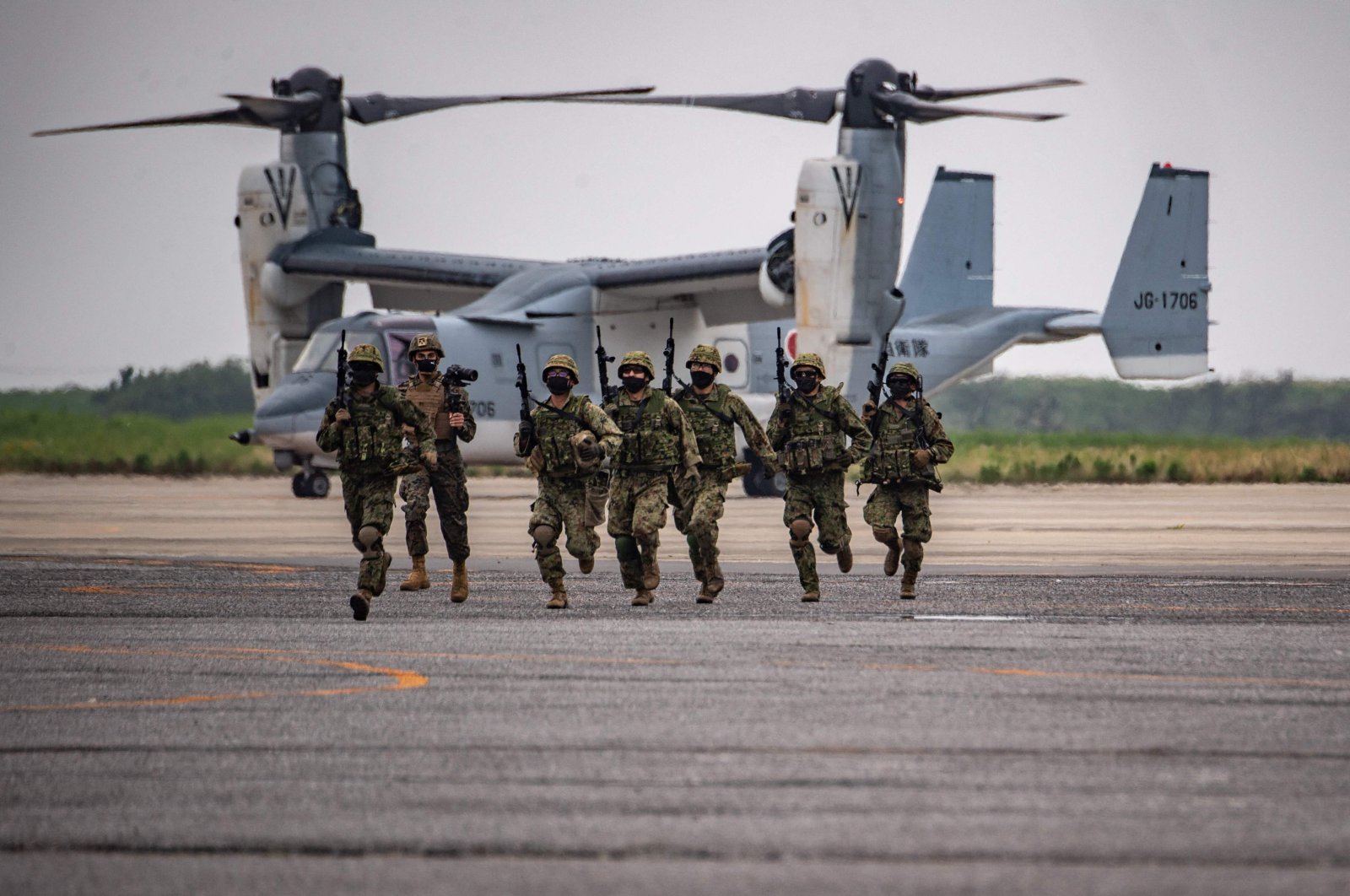 Members of the Japan Ground Self-Defense Force take part in a military display in front of a V-22 Osprey at the Japan Ground Self-Defense Force&#039;s Camp Kisarazu in Chiba prefecture, Japan, June 16, 2022. (AFP Photo)