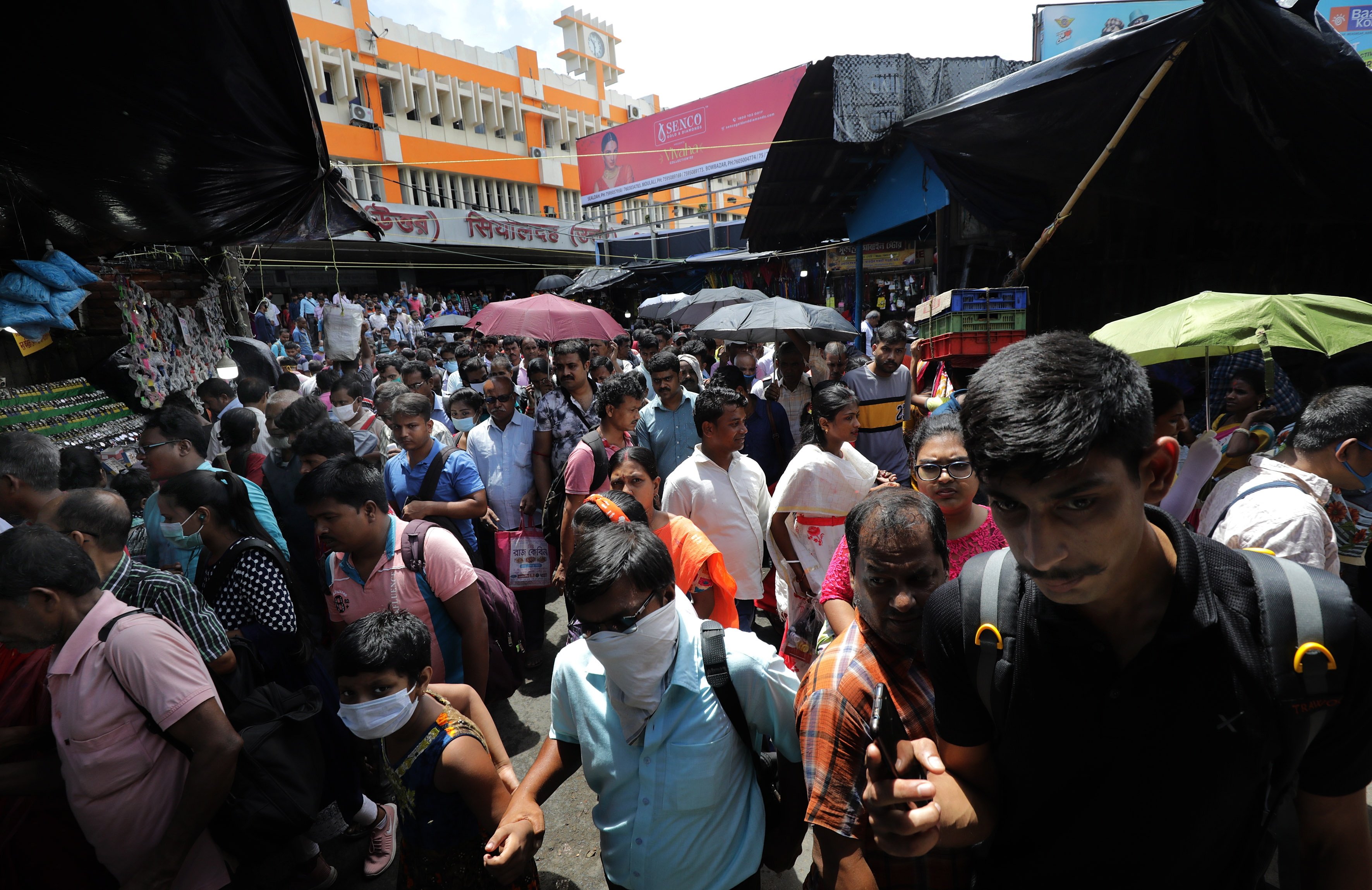 Indian commuters walk through a market near a rail station in Kolkata, India, July 11, 2022.   (EPA/PIYAL ADHIKARY)
