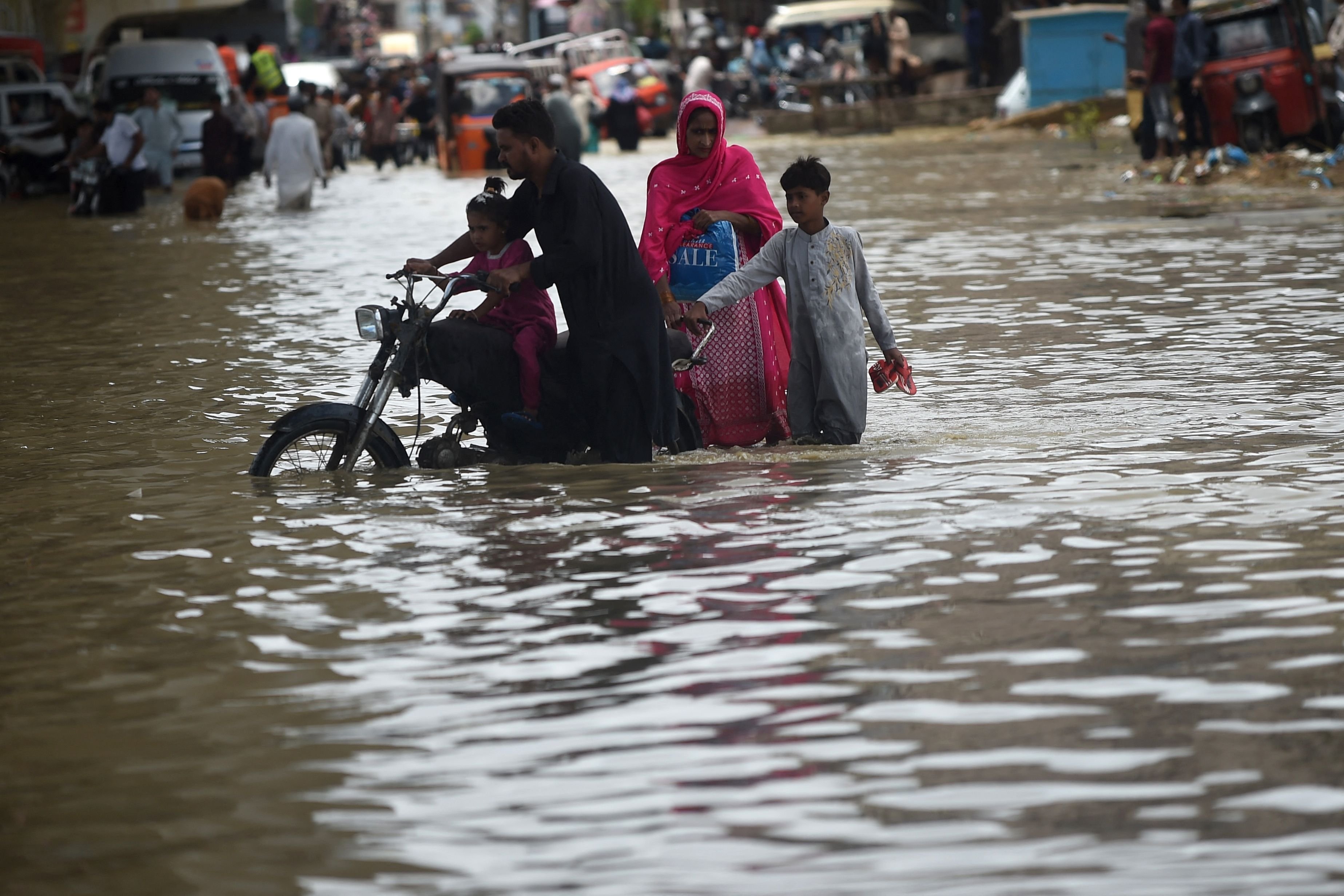 A family wades through a flooded street after a heavy rain shower in Karachi, Pakistan, July 11, 2022. (AFP Photo)