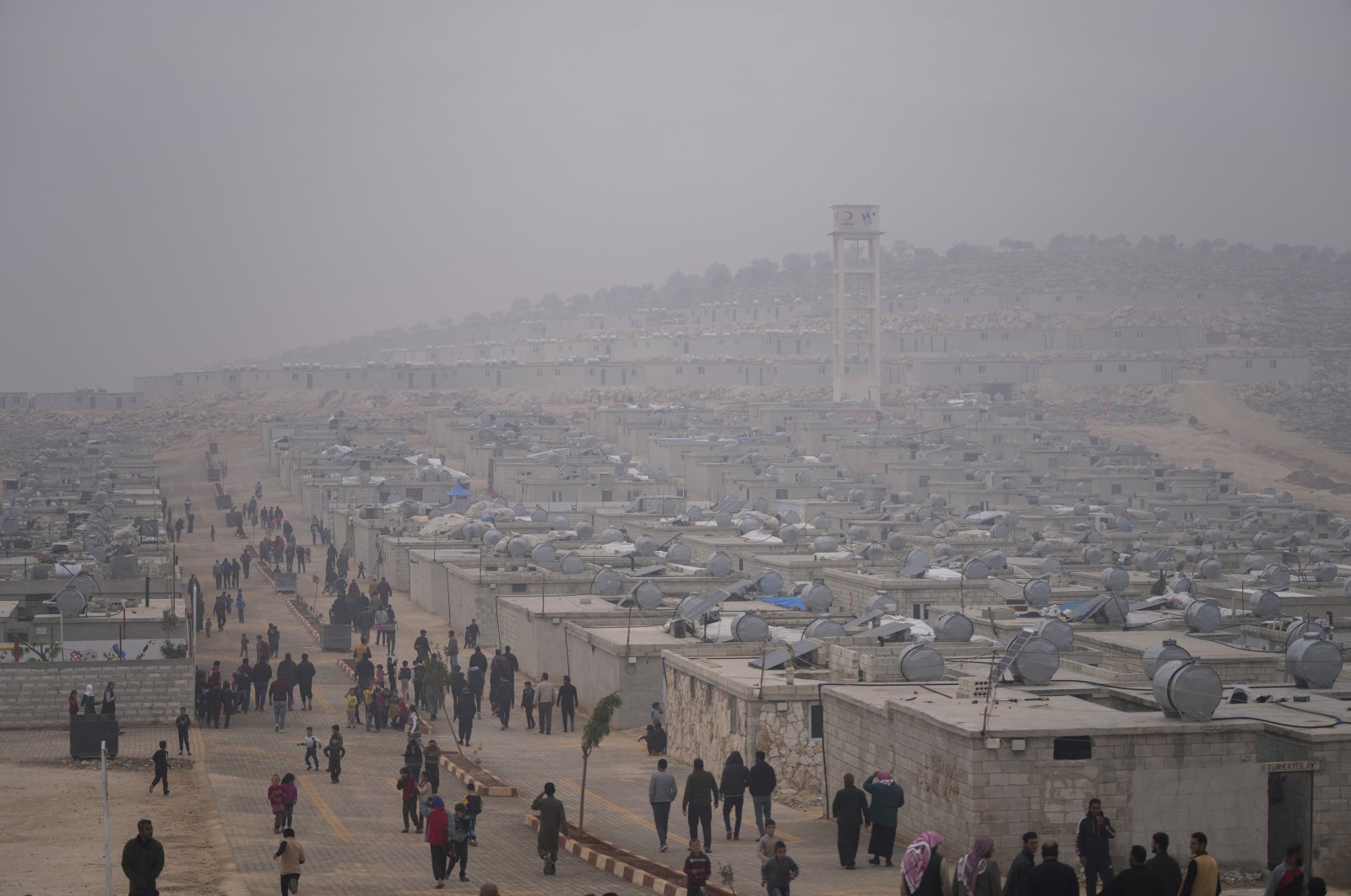 Syrians walk along in a refugee camp for displaced people run by the Turkish Red Crescent in Sarmada district, north of Idlib city, Syria, Nov. 26, 2021. (AP Photo)
