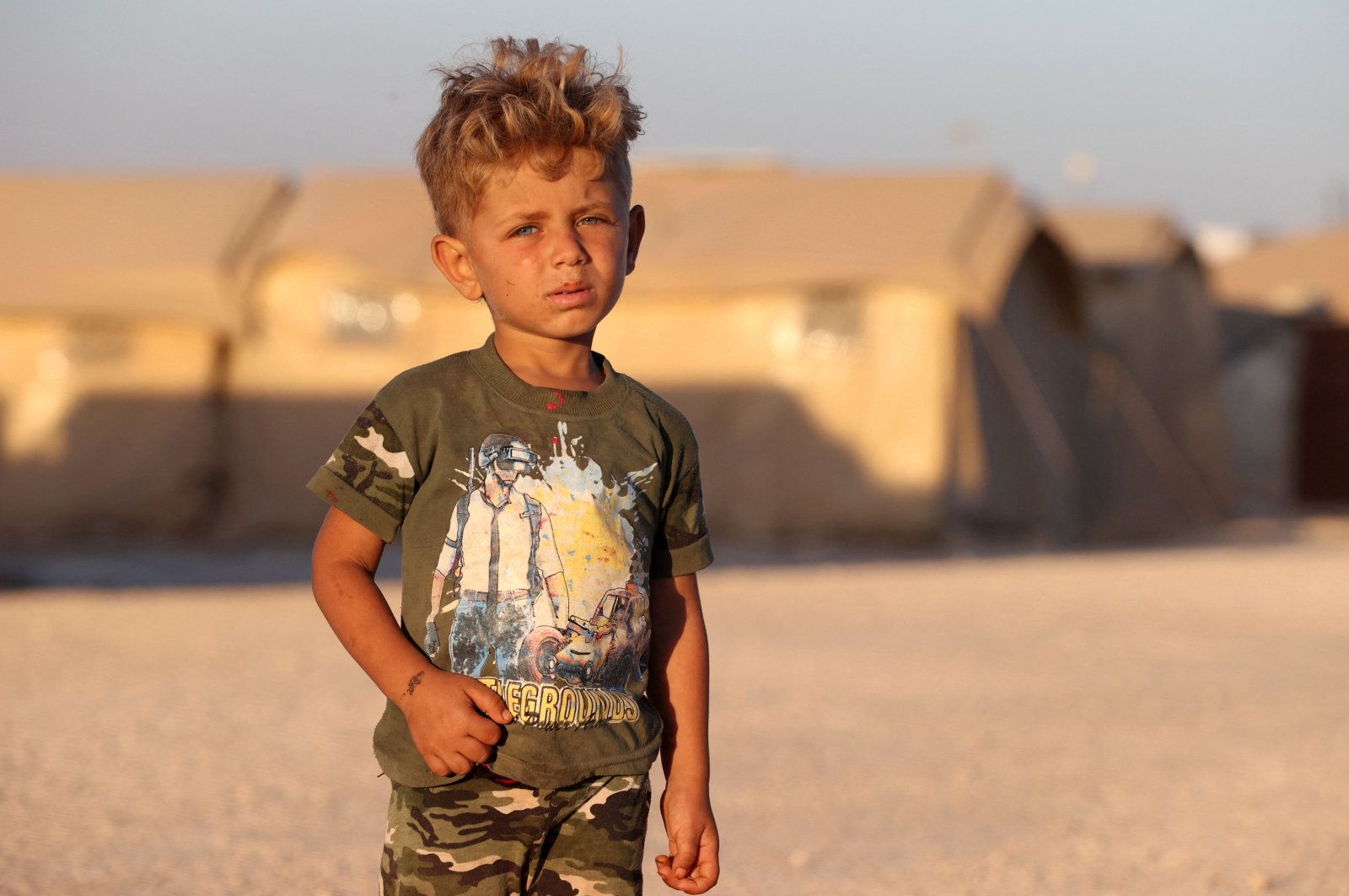 A boy looks on as he stands near tents at a camp for Syrians displaced by conflict near the town of Maaret Misrin in the northern part of the northwestern Idlib province during Eid al-Adha, July 10, 2022. (AFP Photo)