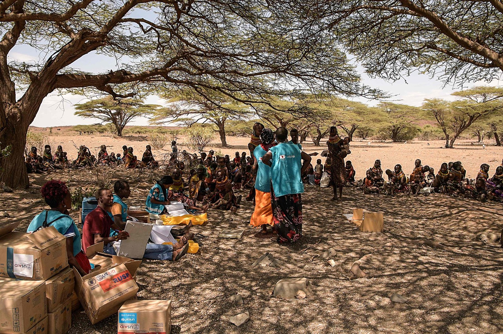Villagers gather under a tree in Purapul village, Loiyangalani area, during World Vision-supported health interventions that help communities tackle malnutrition and other health problems caused by drought, in Marsabit, northern Kenya, July 12, 2022. (AFP Photo)