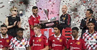 Man Utd's Bruno Fernandes (2nd L) and manager Erik ten Hag hold the trophy after winning their preseason match against Liverpool, Bangkok ,Thailand, July 12, 2022. (AP Photo)