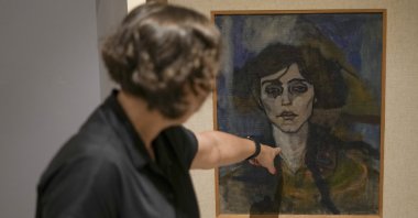 Inna Berkowits, an art historian at the Haifa University's Hecht Museum explains about Amadeo Modigliani's painting "Maud Abrantes" that is painted on the reverse side of a canvas with another painting by him titled, "Nude with a Hat,” and is on display at Haifa University's Hecht Museum in Haifa, Israel, June 28, 2022. (AP)