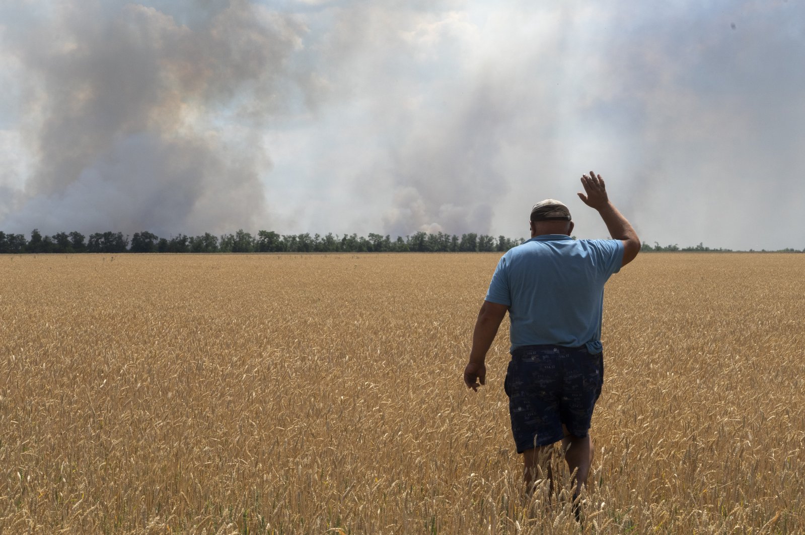 A farmer reacts as he looks at his burning field caused by the fighting at the front line in the Dnipropetrovsk region, Ukraine, July 4, 2022. (AP Photo)