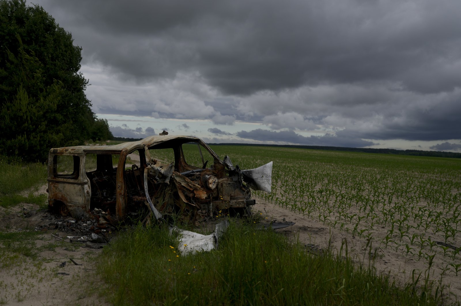 The wreckage of a burned out van that triggered an anti-tank mine, killing its three occupants, lies by the side of a dirt track in Andriyivka, on the outskirts of Kyiv, Ukraine, Tuesday, June 14, 2022. (AP Photo)