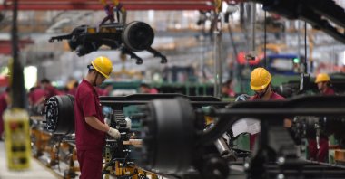 Employees work on an assembly line producing trucks at a factory in Fuyang in Anhui province, eastern China, July 15, 2022. (AFP Photo)