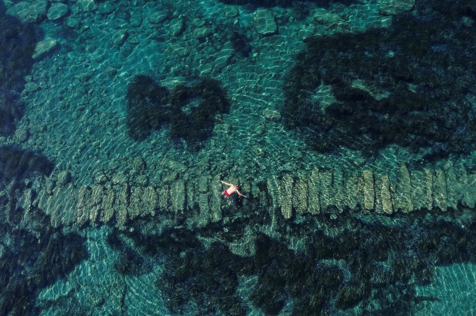 A visitor looks at the ruins as he swims at the underwater archaeological park of the ancient port of Amathus in Limassol, Cyprus, July 9, 2022. (Reuters Photo)