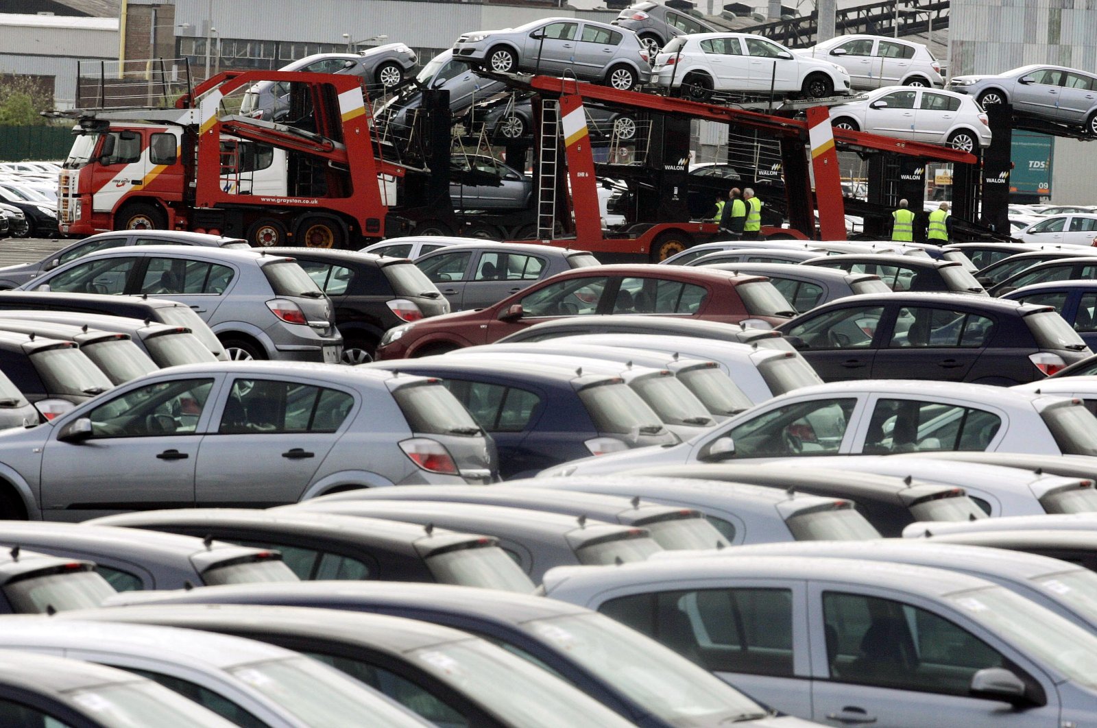 A car transporter is loaded amongst rows of Vauxhall Astra cars outside the Vauxhall plant at Ellesmere Port near Liverpool, northern England on May 16, 2006.