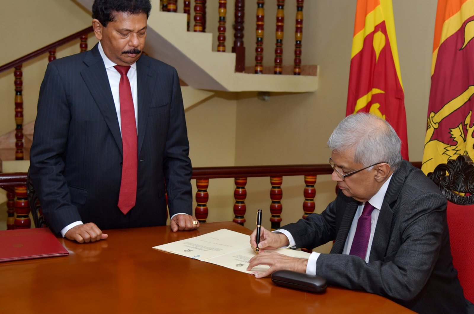 A handout photo made available by the Sri Lankan President&#039;s Media Division shows Sri Lankan Prime Minister Ranil Wickremesinghe (R) signing a document after taking the oath as interim president of Sri Lanka before Chief Justice Jayantha Jayasuriya (L), Colombo, Sri Lanka, 15 July 2022. (Sri Lankan President&#039;s Media Division via EPA Photo)