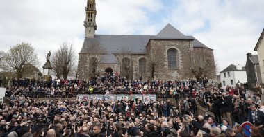 A crowd watches French President Emmanuel Macron arriving in the village of Spezet, Brittany, France, April 5, 2022. (AP Photo)
