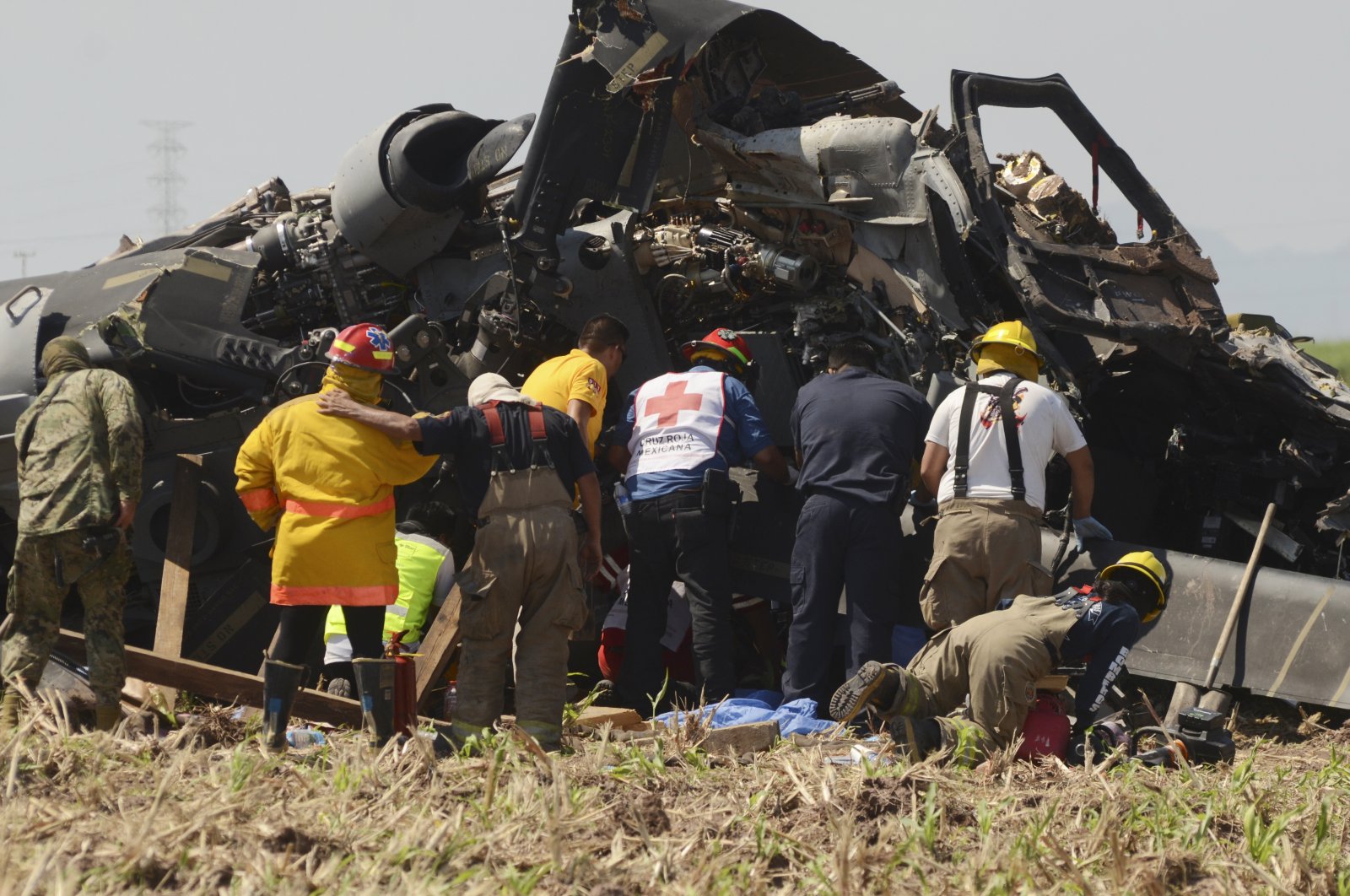 Emergency personnel work next to a Mexican navy helicopter that crashed after providing support for the operation that captured drug lord Rafael Caro Quintero, near Los Mochis, Sinaloa state, Mexico, July 15, 2022. (AP Photo)