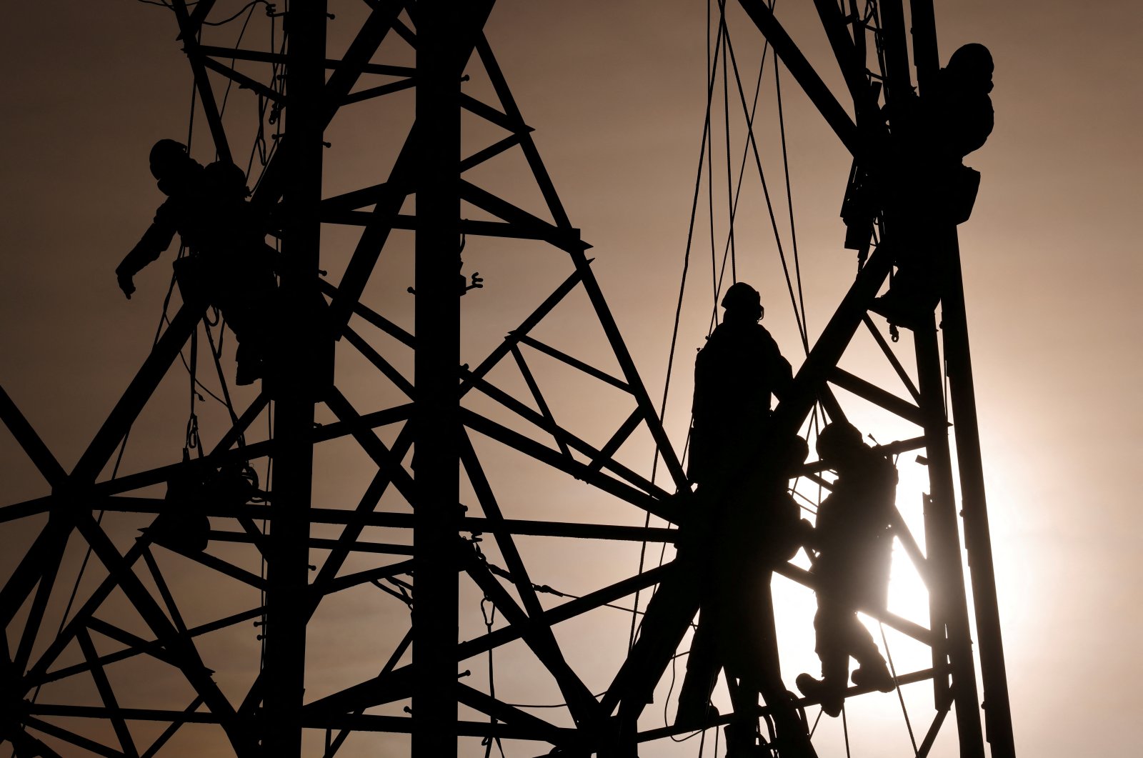 Technicians work on an electricity pylon in Bourbourg, France, Feb. 18, 2021. (Reuters File Photo)