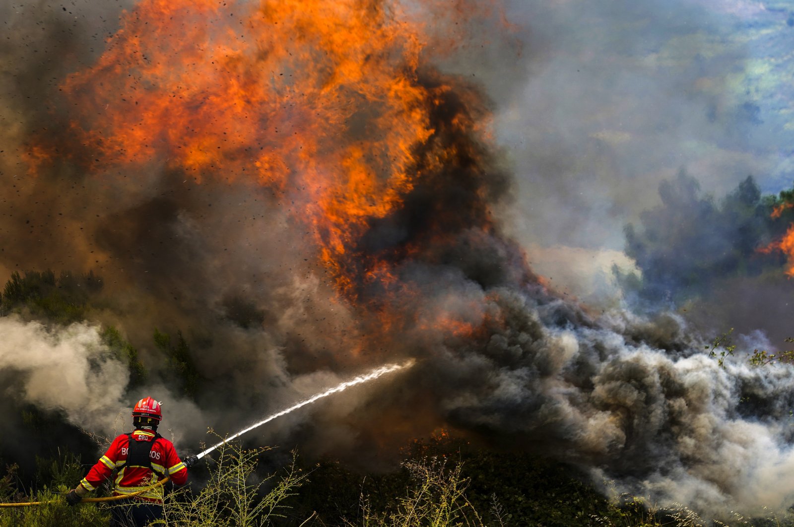 A firefighter fights the flames surrounding Ancede village during a wildfire in the municipality of Baiao, north of Portugal, July 15, 2022. (EPA-EFE Photo)