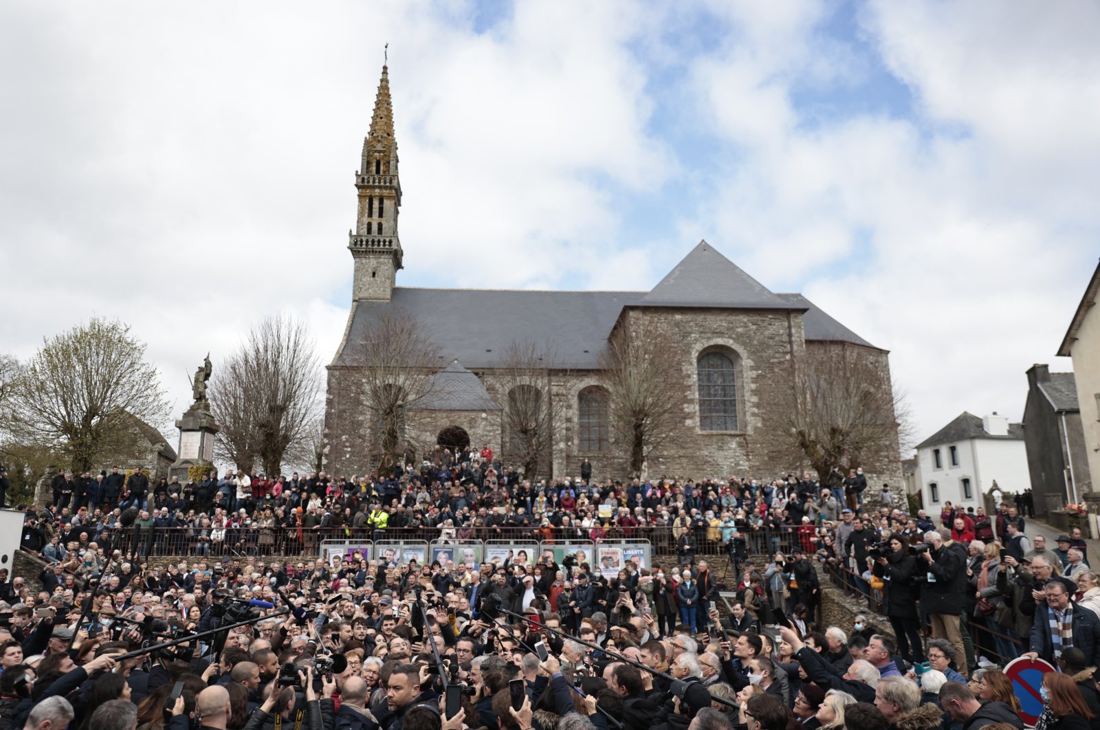A crowd watches French President Emmanuel Macron arriving in the village of Spezet, Brittany, France, April 5, 2022. (AP Photo)
