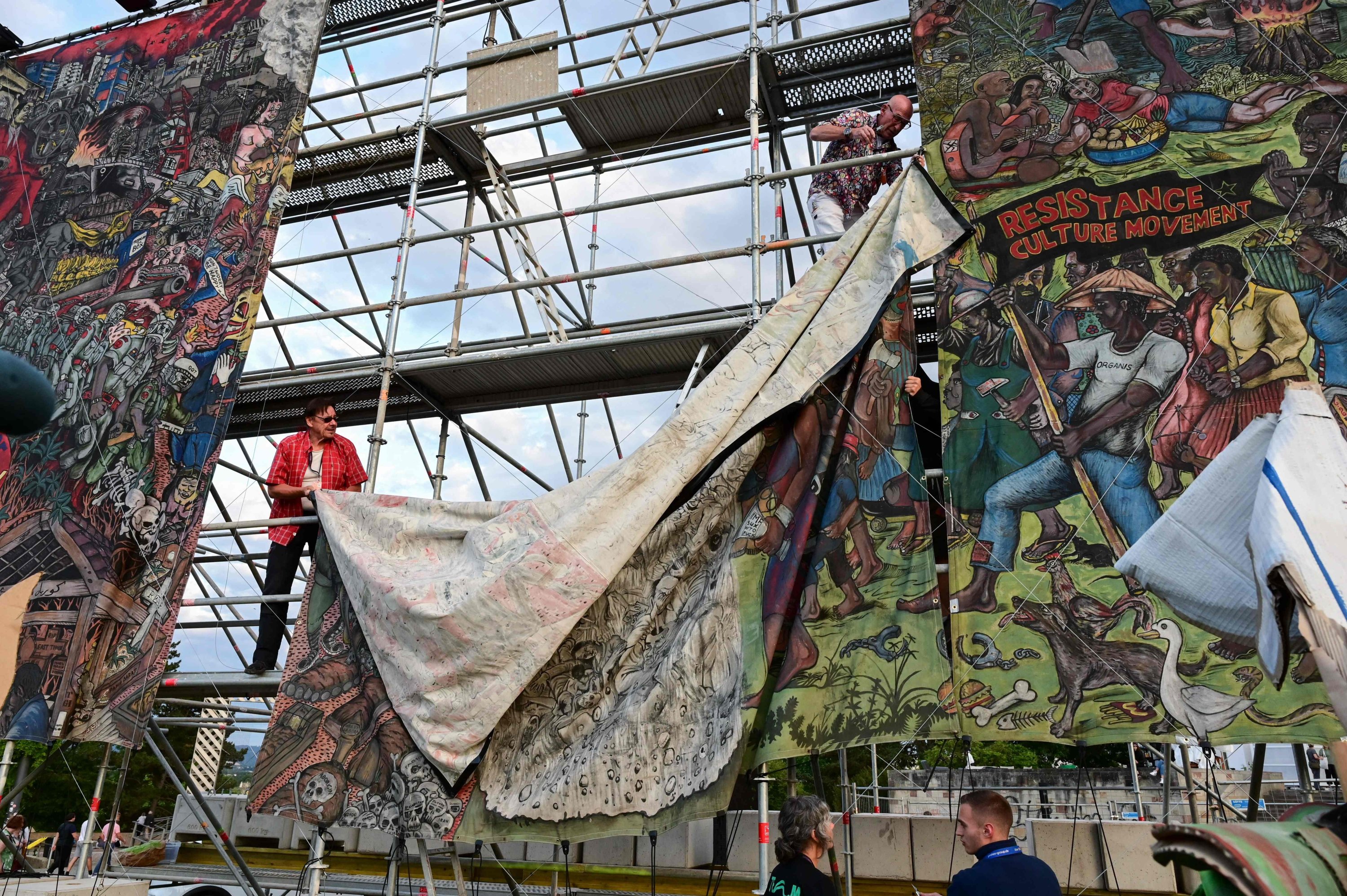 Documenta staff members remove a large-scale banner of 