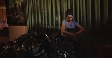 A woman ties plastic bags with humanitarian aid for people, from the Selidove city council, in Donetsk Oblast, eastern Ukraine, July 15, 2022. (AP Photo)