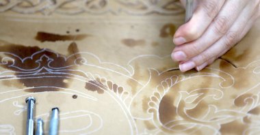 An artist works on skin and leather artwork, in Bursa, Turkey, July 17, 2022. (AA Photo)