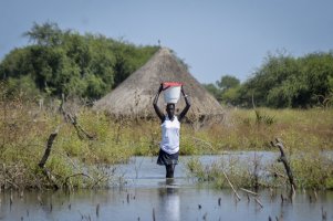 A woman carries a bucket on her head as she wades through floodwaters in the village of Wang Chot, Old Fangak county, Jonglei state, South Sudan, Nov. 26, 2020. (AP Photo/Maura Ajak, File)