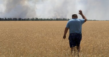 A farmer reacts as he looks at his burning field caused by fighting at the front line in the Dnipropetrovsk region, Ukraine, July 4, 2022. (AP Photo)