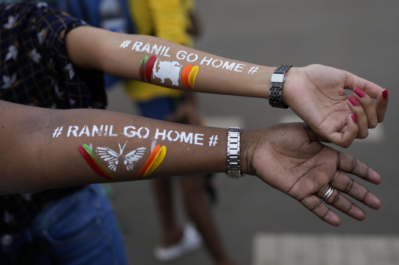 Girls display their arms painted with the message &quot;Ranil go home,&quot; referring to Prime Minister Ranil Wickremesinghe, at the protest site in Colombo, Sri Lanka, July 17, 2022. (AP Photo)