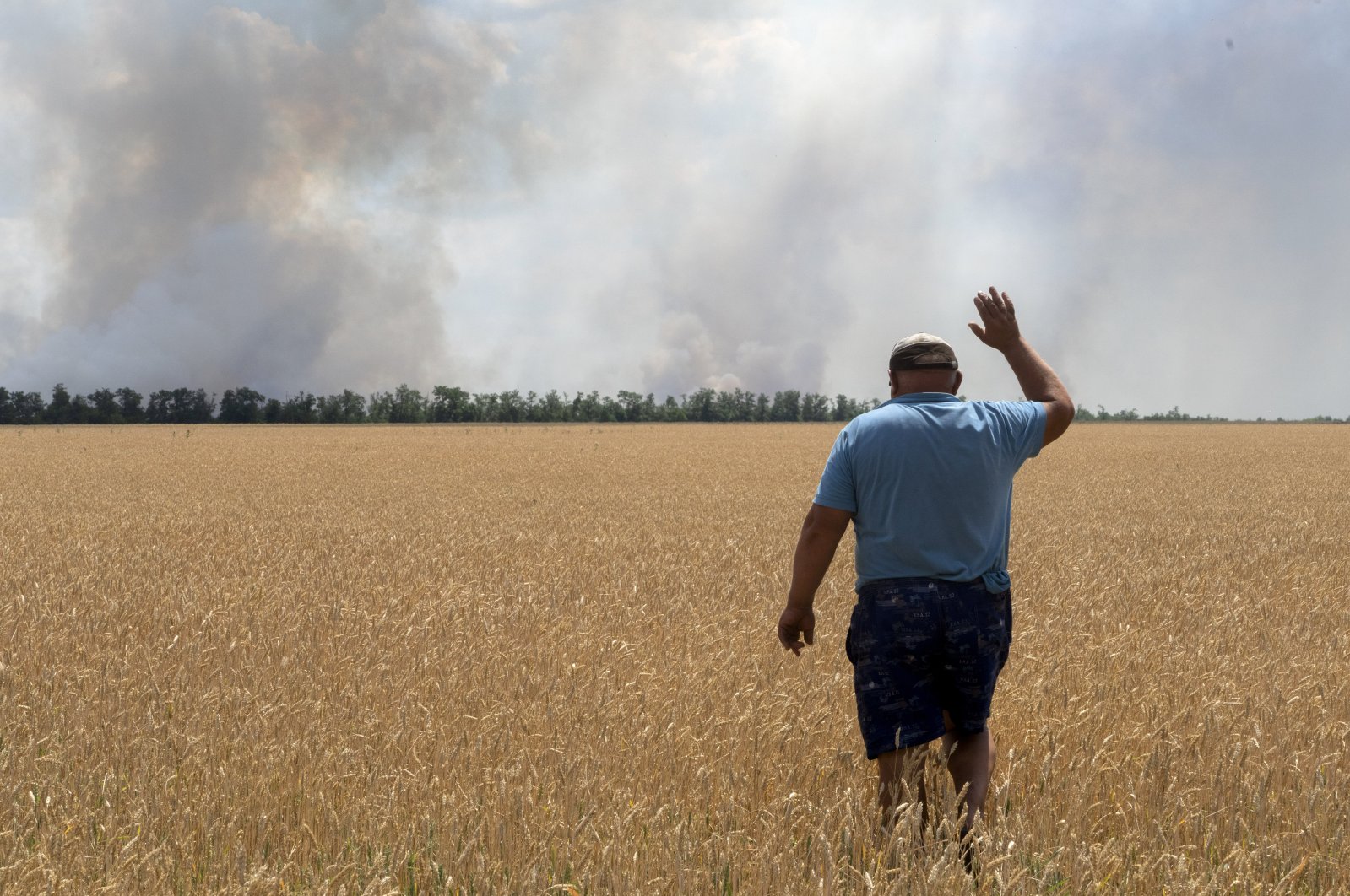 A farmer reacts as he looks at his burning field caused by fighting at the front line in the Dnipropetrovsk region, Ukraine, July 4, 2022. (AP Photo)