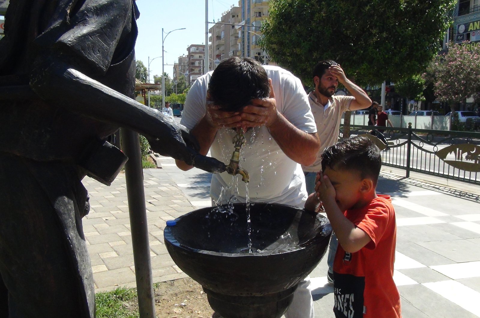 People wash their faces amid hot weather, in Şanlıurfa, southeastern Turkey, July 16, 2022. (İHA PHOTO)
